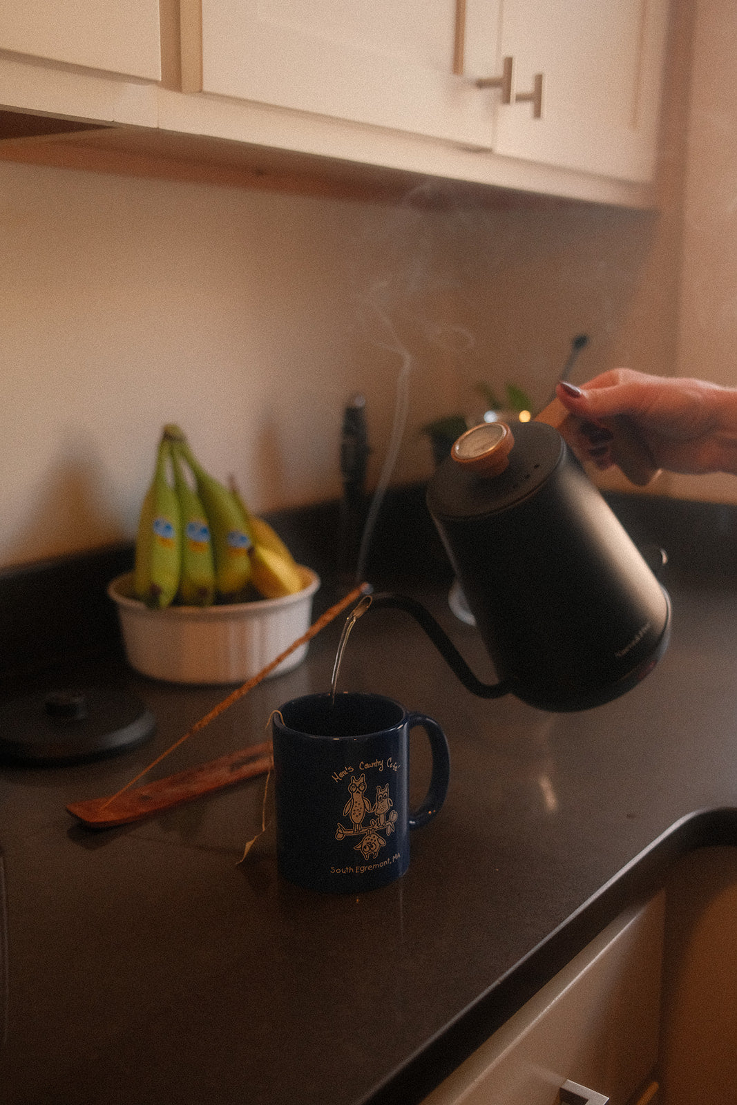 Pouring hot water into a mug of Doze Tea herbal tea for a nighttime relaxation routine