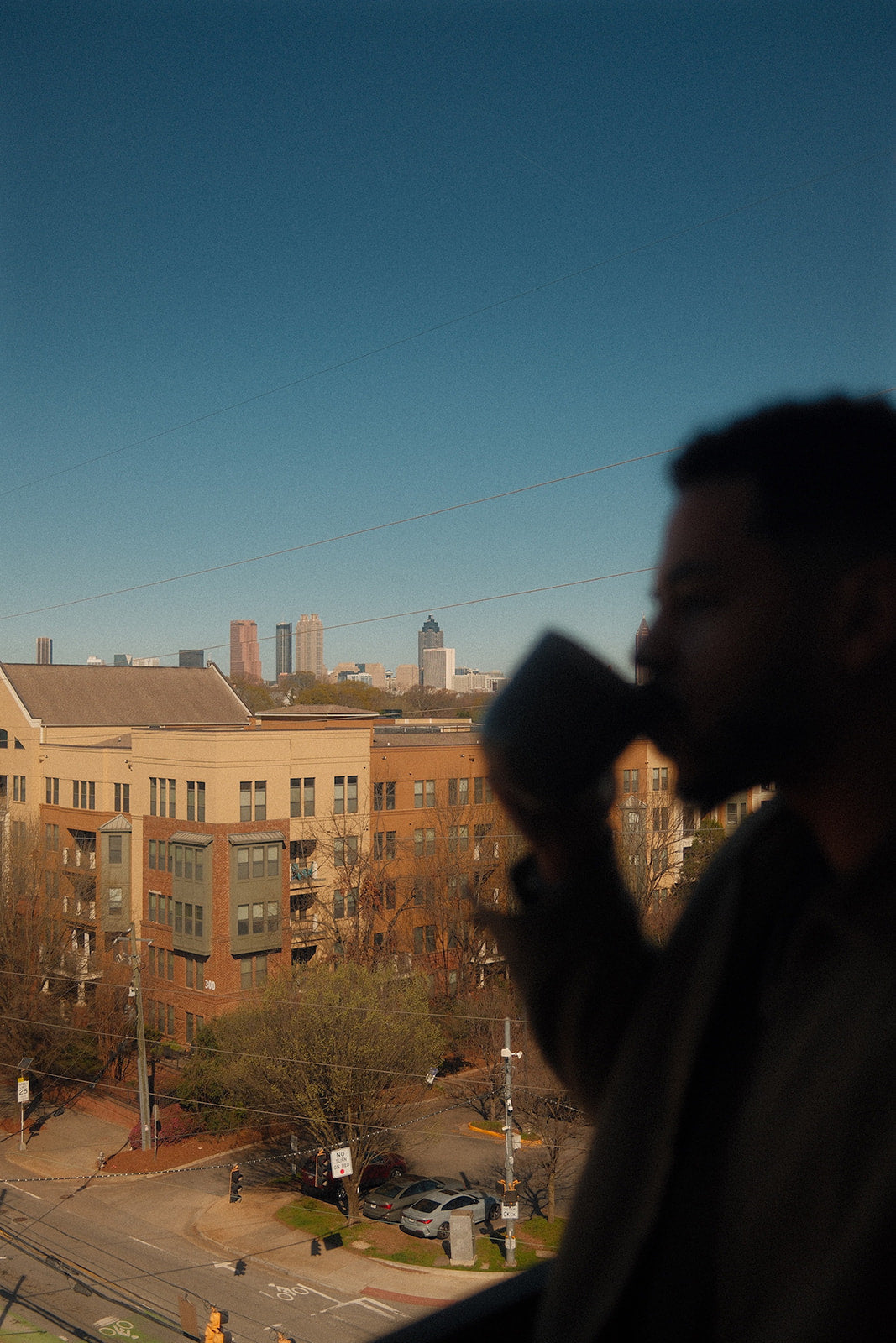 Man drinking Doze Tea herbal tea with the Atlanta skyline for a relaxing city moment