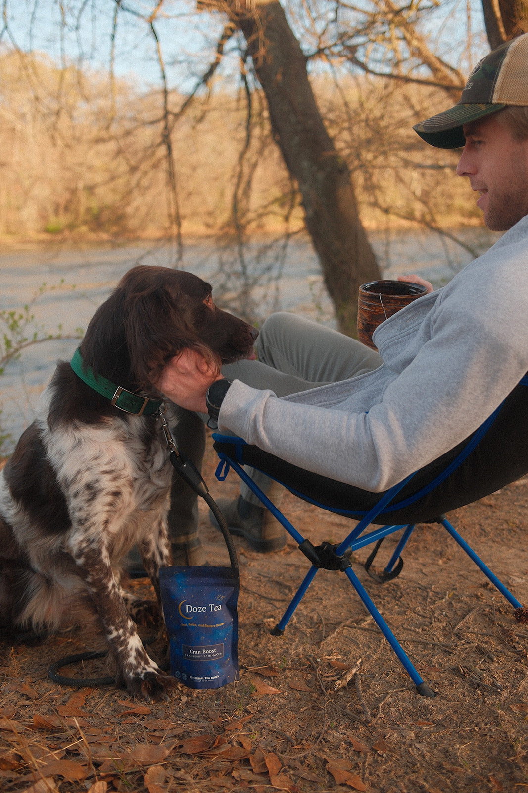 Doze Tea herbal tea at a cozy campsite with a person and dog for a relaxing outdoor evening